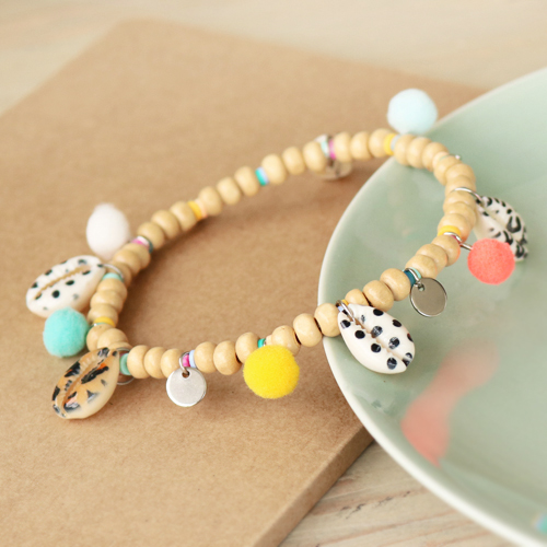 Deze kleurrijke items kun je maken met Kauri schelp kralen en pompom bedels: