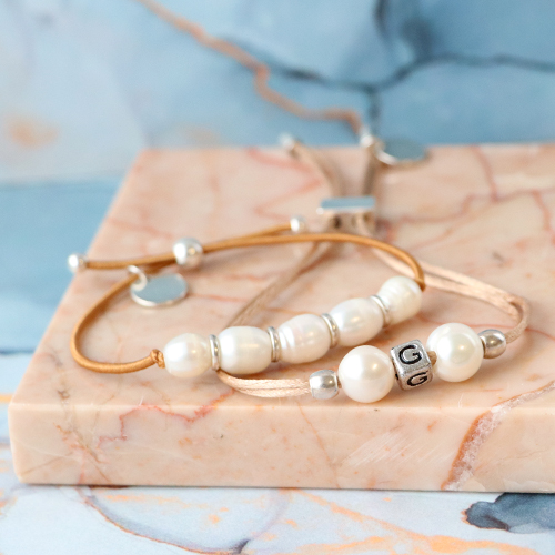 Trendy armbanden maken met zoetwaterparels, satijn draad en gekleurd elastiek doe je zo: