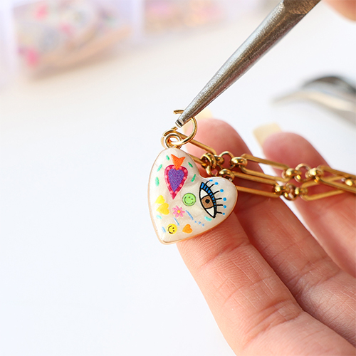 Maak een funky bedelketting met metalen bedels met enamel