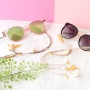 Zomerse zonnebrilkoorden met gouden details en minimalistische oorbellen van stainless steel.