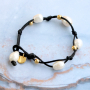 Trendy armbanden maken met zoetwaterparels, satijn draad en gekleurd elastiek doe je zo: