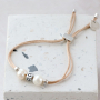 Trendy armbanden maken met zoetwaterparels, satijn draad en gekleurd elastiek doe je zo: