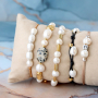 Trendy armbanden maken met zoetwaterparels, satijn draad en gekleurd elastiek doe je zo: