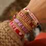 Maak vrolijke armbanden met tekstlint en bead stoppers